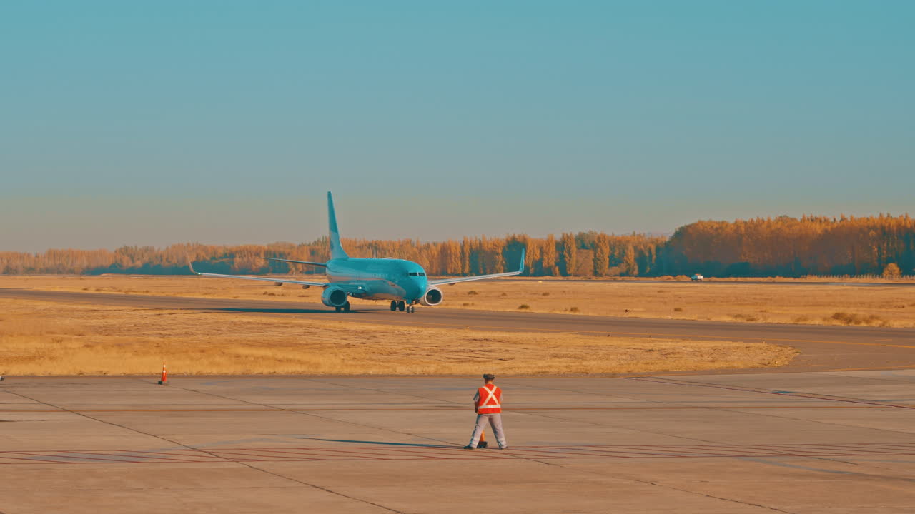 Jet passeggeri in rullaggio sulla pista dell'aeroporto con il personale di terra