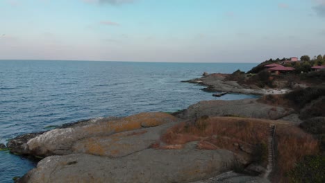 aerial shot over the rocky seashore, filmed by drone before sunset, clip end in open sea - lozenets, bulgaria