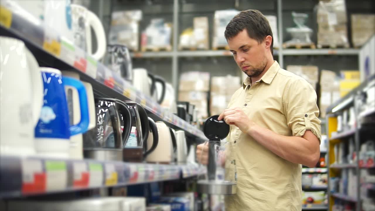 hombre comprando hervidores eléctricos en una tienda de electrodomésticos