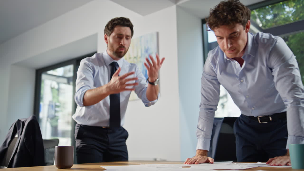 Mad startupers watching papers feeling angry in panoramic workplace closeup