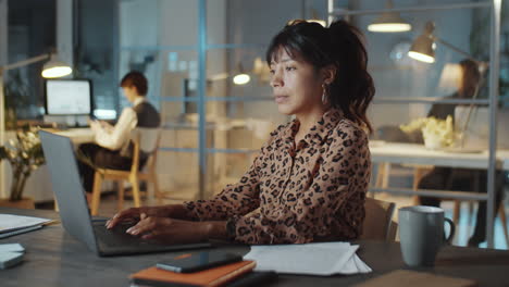 Mujer-De-Negocios-Hispana-Usando-Una-Laptop-En-La-Oficina-Por-La-Noche