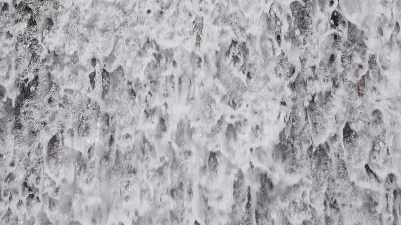 Close-up of water splashing down a waterfall, creating white foam and dynamic natural flow