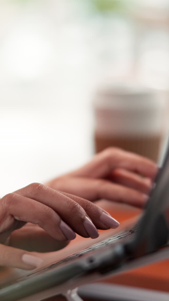Digitando su un portatile con del caffè vicino