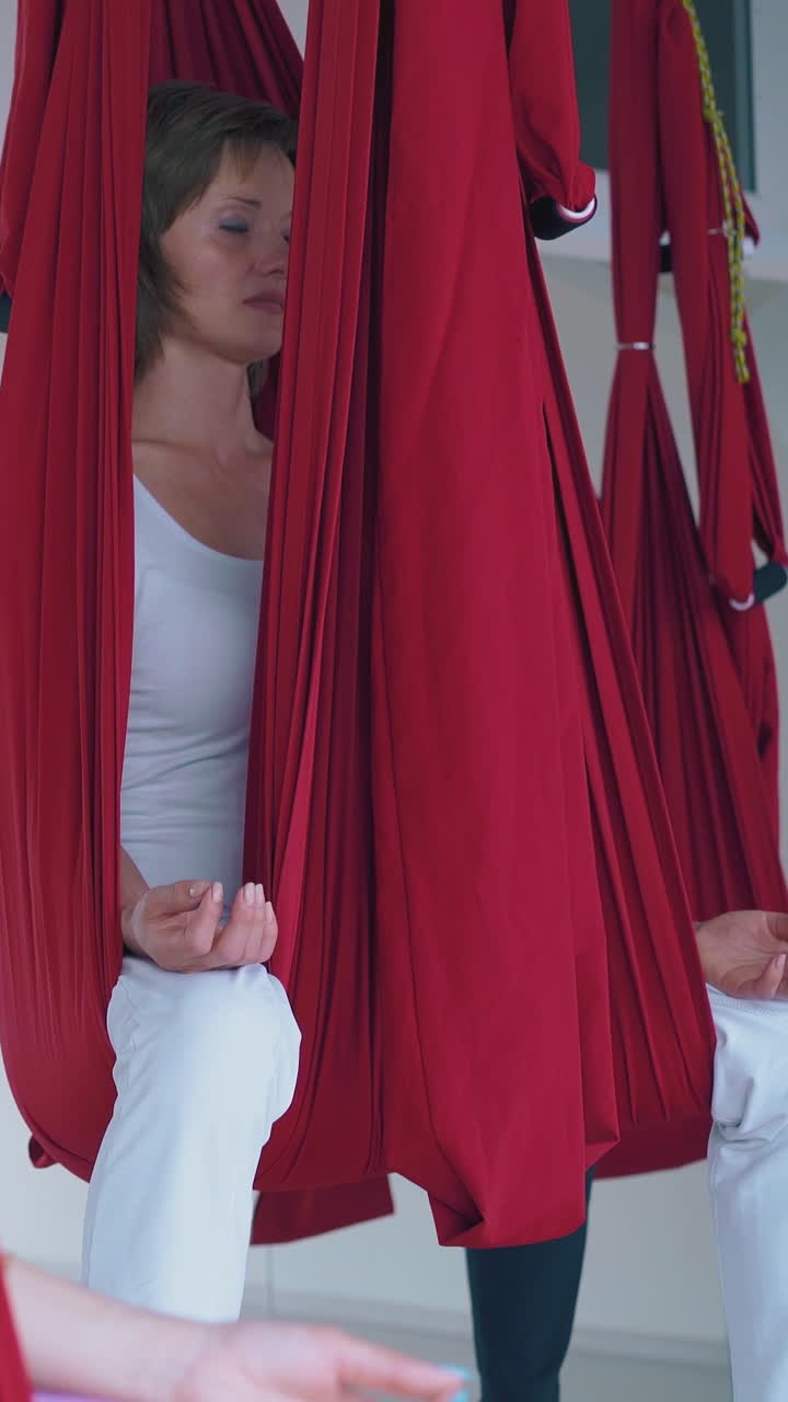 oriental fly yoga hammocks hold ladies group relaxing and meditating with fingers in gyan mudra position close view