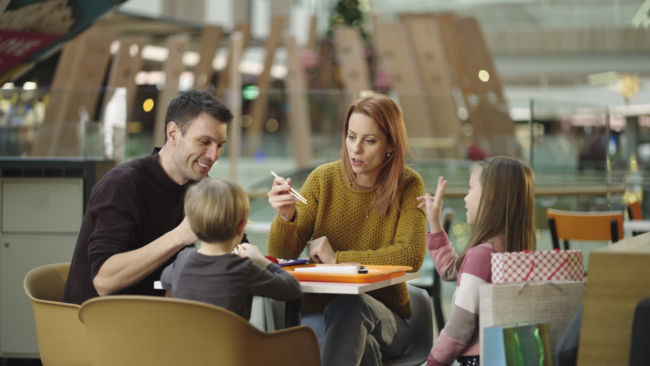 Family eating together in a mall food court