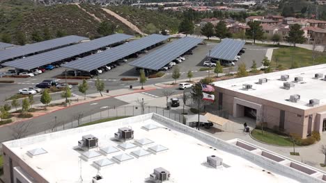 a high school with sustainable energy solar panels in santa clarita, los angeles. aerial flyover.