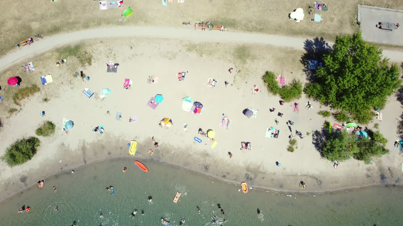 Aerial View of a Lakefront Beach with People Enjoying the Summer