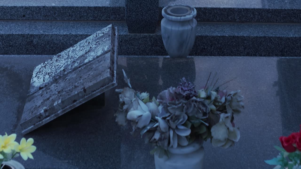Cattura l'atmosfera pacifica di un cimitero al tramonto. Lapidi adornate con fiori e simboli religiosi creano una scena solenne e suggestiva a Ferntree Gully, Melbourne.