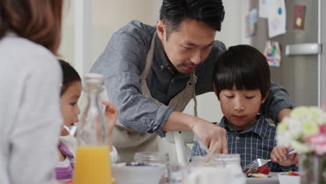 Familia-Asiática-Feliz-Comiendo-Panqueques-Para-El-Desayuno,-Niños-Disfrutando-De-Una-Comida-Casera-Saludable-Con-Sus-Padres-El-Fin-De-Semana-Por-La-Mañana-En-La-Cocina,-Imágenes-De-4k