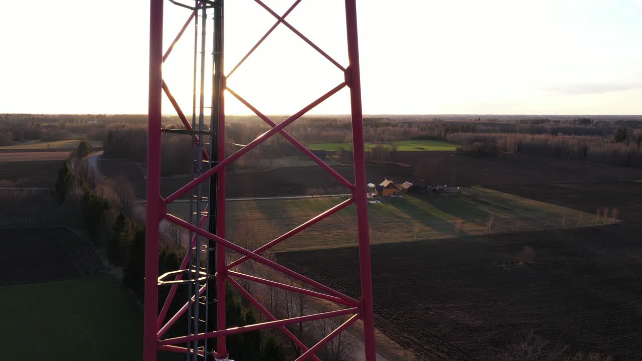 Communication tower antenna in sun rays in drone descends close up view