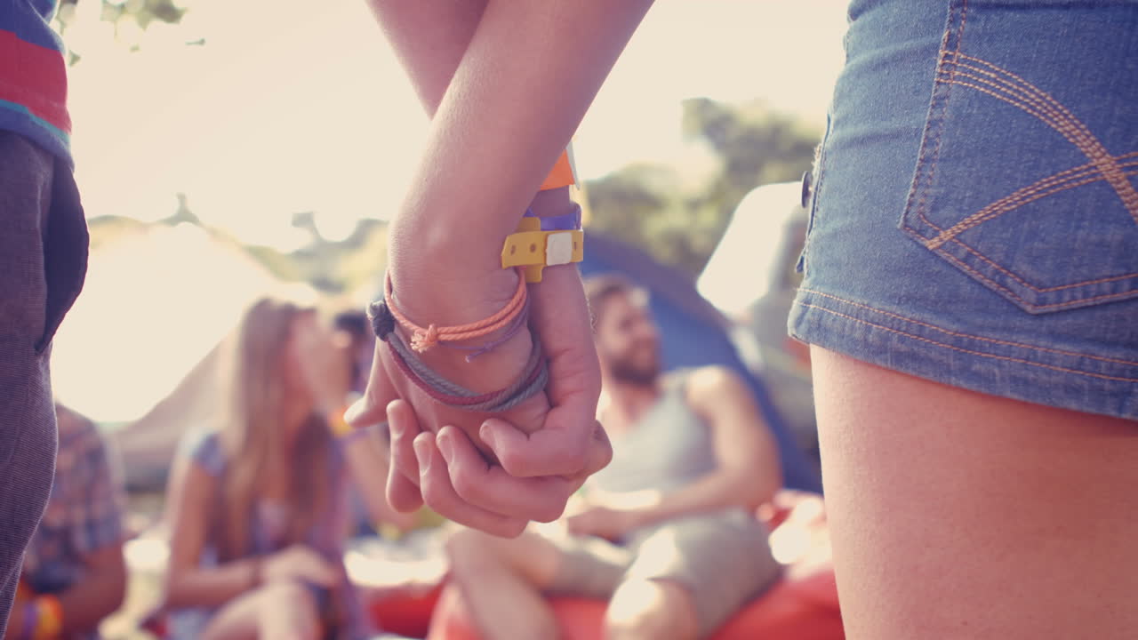In high quality format hipster couple holding hands on campsite 