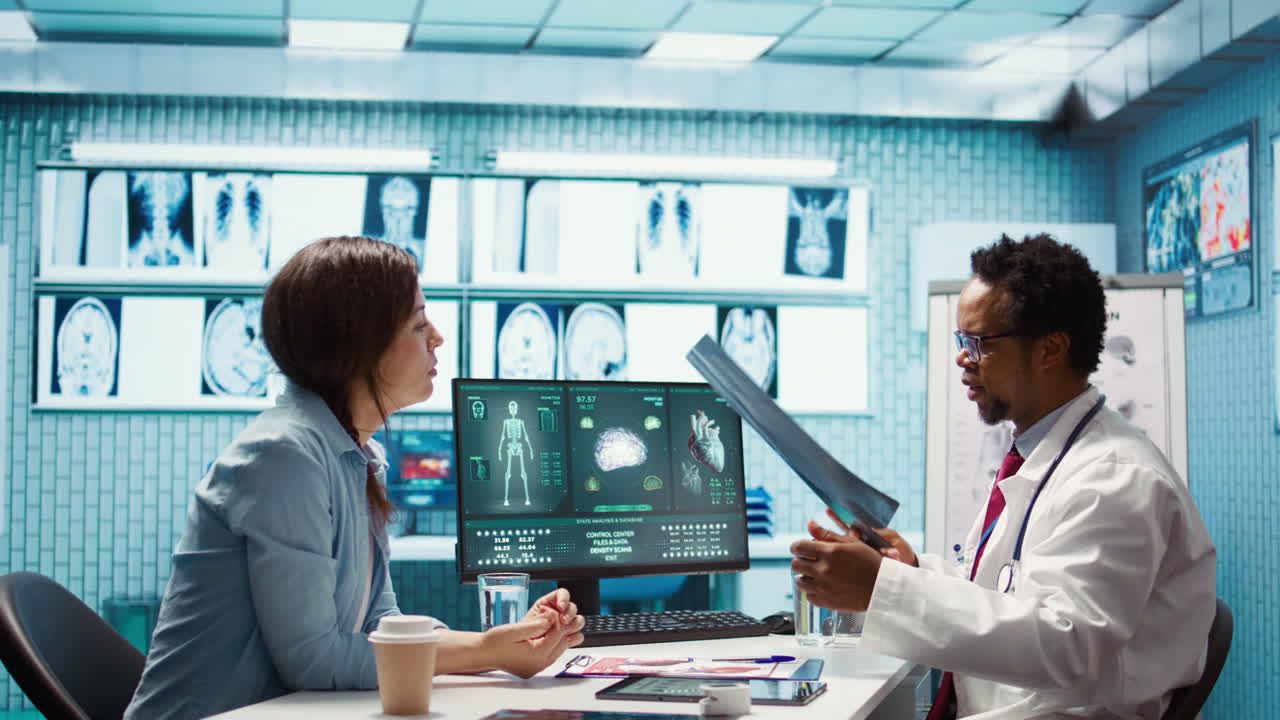 Physician reviewing MRI scan and x ray results with a patient in medical office