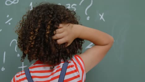 Rear-view-of-mixed-race-schoolgirl-scratching-her-head-in-classroom-at-school-4k