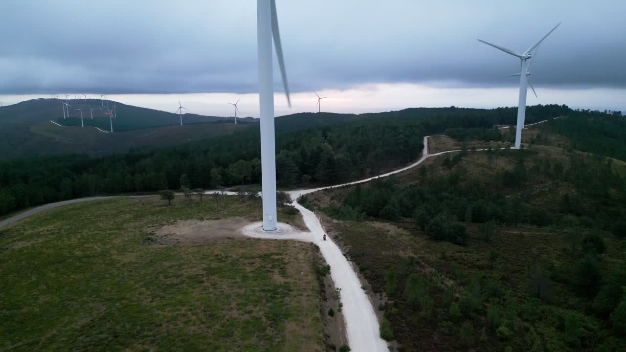 мотоцикл едет по ферме ветряных мельниц вид с воздуха