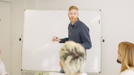 man using a board during an explanation in a meeting