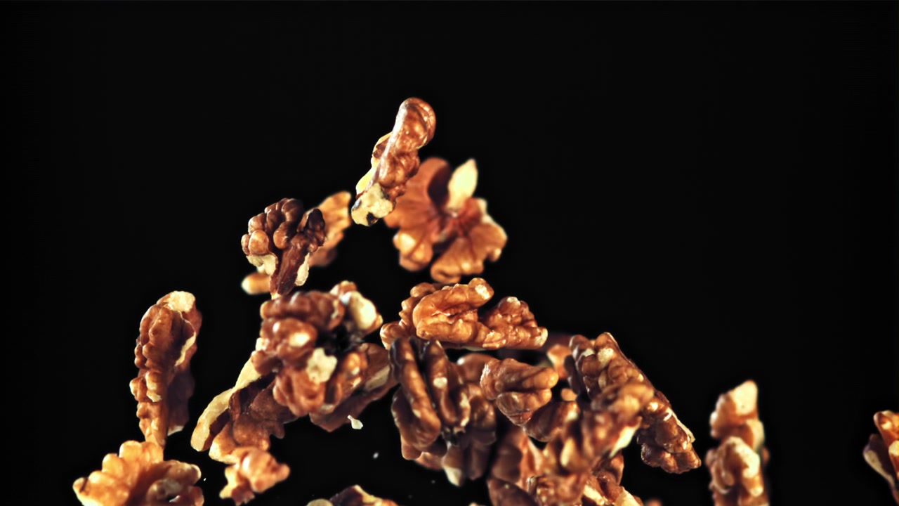 Walnuts Floating in Slow Motion Against a Black Background