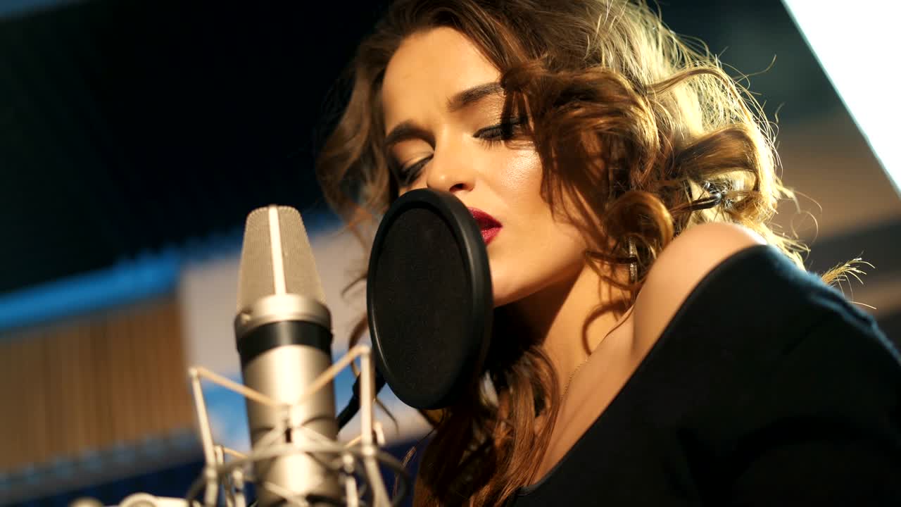 Beautiful young singer who recorded a song in a professional recording studio.