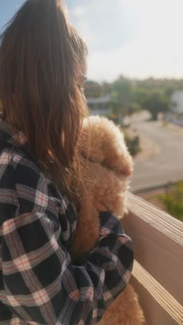 girl with her puppy on a balcony