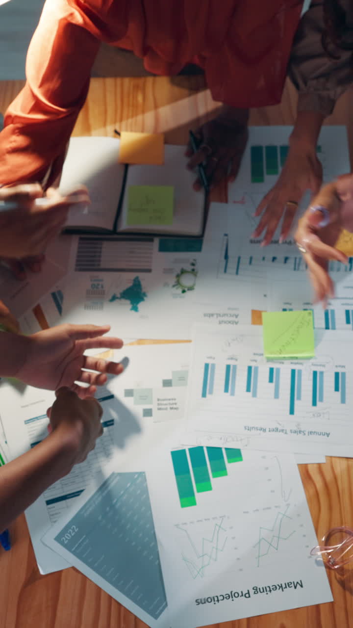 Overhead View of Business Team Collaborating on Documents and Charts