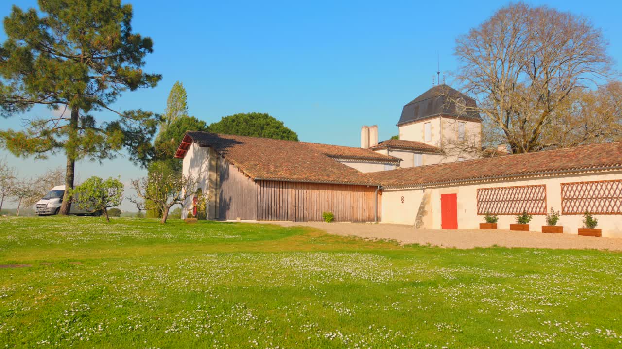 Discover the tranquil beauty of Francois Mauriac's house in Malagar, France, surrounded by lush greenery. The scene showcases stunning architecture against a clear blue sky, conveying peacefulness