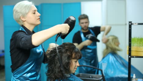 process of creating hair style. beautiful woman getting haircut by hairdresser in the beauty salon