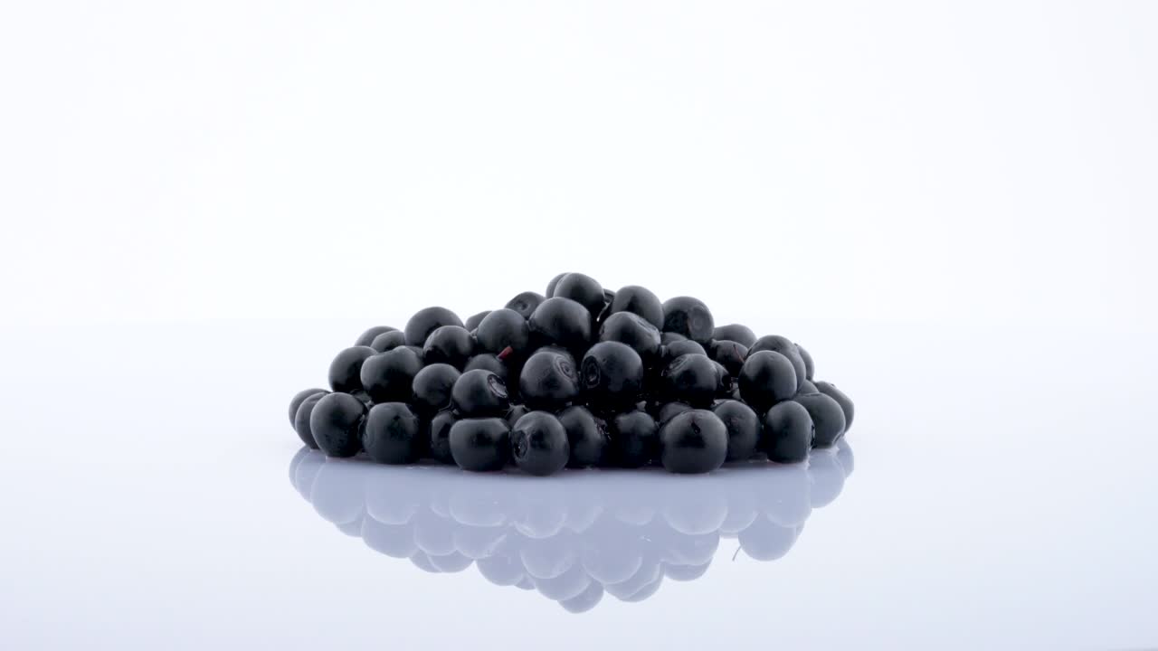 Heap of blueberries rotating on the on the turntable isolated on the white background. Close up.