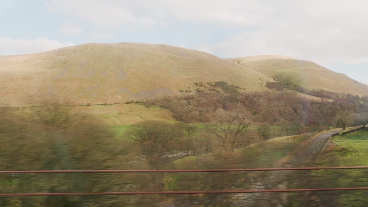 montaña, pradera y ciudad rural desde el tren que viaja durante el día