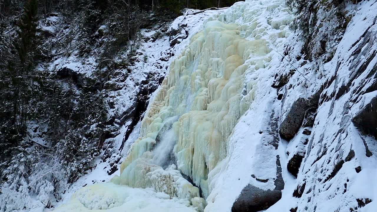 Vesiputouksen jäätynyt seinämä kauniilla jäärakenteilla