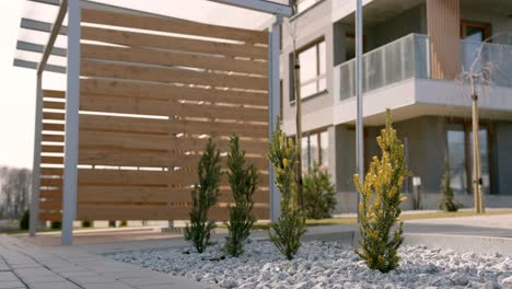 cortile di una moderna casa cubica a 2 livelli di nuova costruzione, con patio esterno in legno