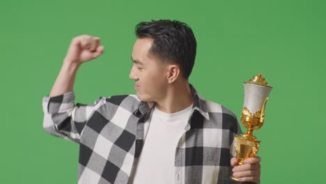 man celebrating victory with a trophy