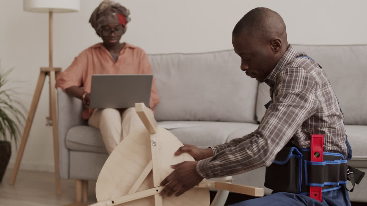 Skillful Joiner Helping African Woman Assembling Furniture
