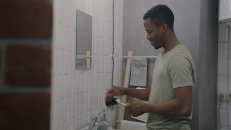 man brushing teeth in bathroom