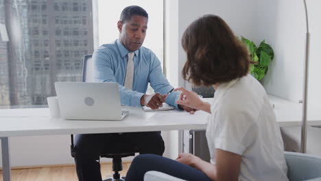 Mujer-Reuniéndose-Con-Un-Asesor-Financiero-Masculino-En-La-Oficina-Y-Firmando-Contrato