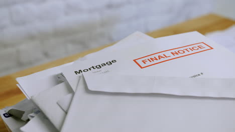 una pila de billetes y cartas con notificación final de deudas hipotecarias