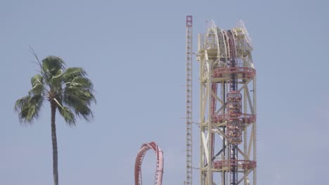 epic close up shot of a roller coaster climbing a lift hill, and then plunging down into a giant loop