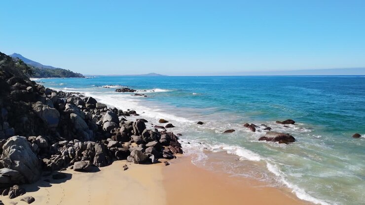 Drone voando ao longo de uma praia escondida em Sayulita, México.