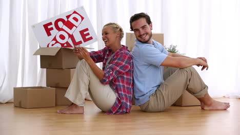 Couple-sitting-back-to-back-laughing