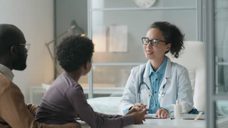 Female-Pediatrician-Giving-Consultation-to-African-American-Kid-and-His-Dad