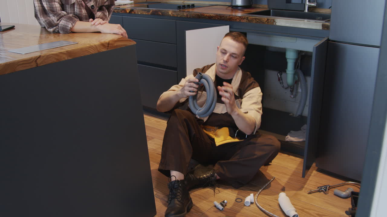 Young Woman Talking to Plumber