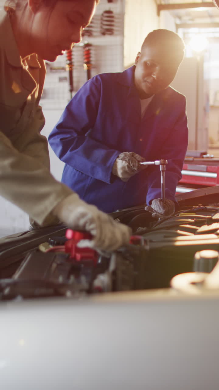 video vertical de dos mecánicas de automóviles femeninas diversas comprobando el coche