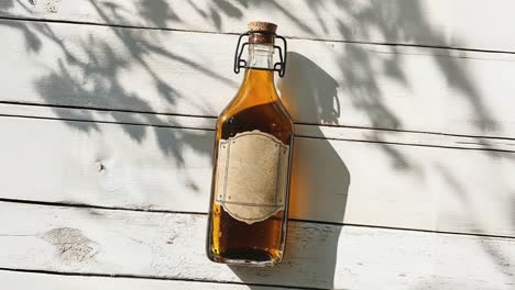 botella de vidrio rústico contra un fondo de madera blanca