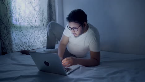 indian-man-working-on-laptop-at-home-during-night-time