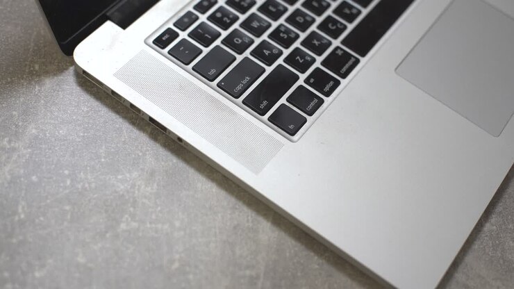 Hand plugging power adapter in laptop, everyday computer technology personal use
