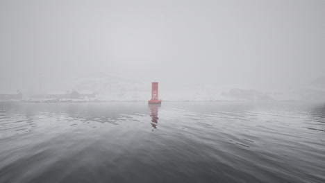 a red buoy in a foggy harbor