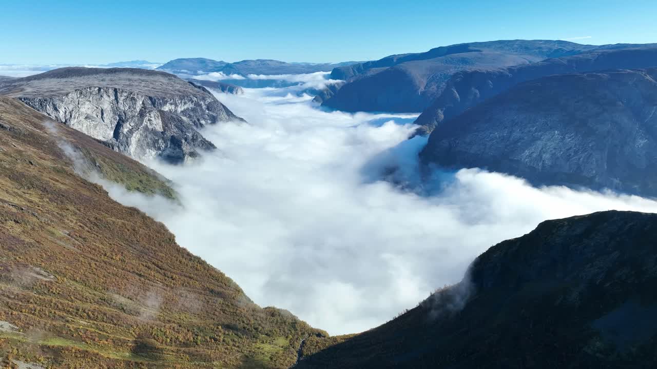 Aerial over Rimstigbotn Valley with Bakkanosi on the right, revealing Naeroyfjord cloud inversion and Breiskrednosi, Bleia, and Granosi mountains in the distance