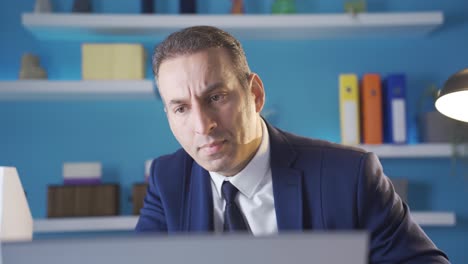 Mature-businessman-looking-focused-on-laptop-in-office.