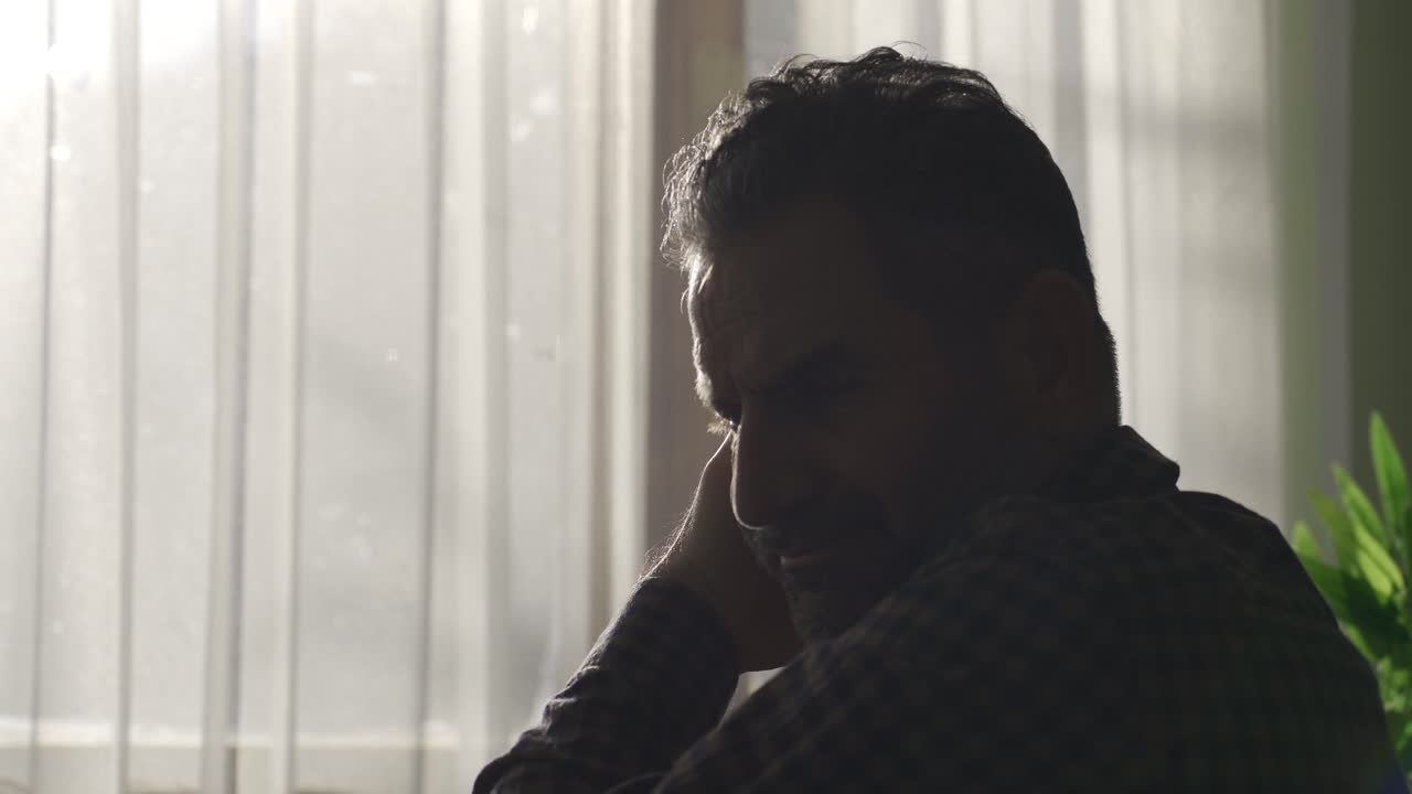 Middle-aged man with depression at home, tired and exhausted.