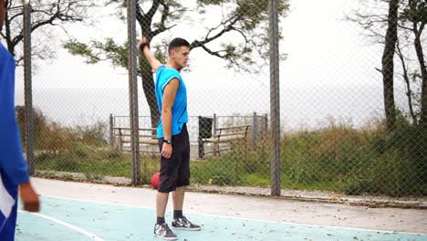 Dos-Jóvenes-Amigos-Calentando-Antes-De-Jugar-Baloncesto-En-La-Calle.-Tiro-En-Cámara-Lenta