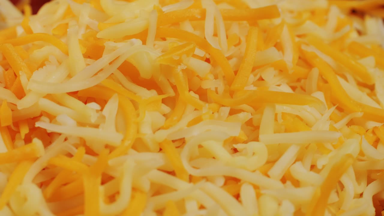 Some different sorts of grate cheese on plate close up macro. Chef grating cheese mozzarella, cheddar for meals. Itallian food, pizza, pasta. High quality 4k footage