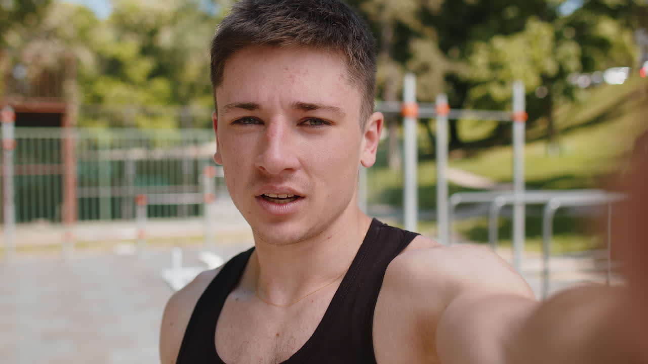 Athletic bodybuilder man records video lessons talking to camera selfie blog vlog for social media